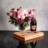 The luxurious floral arrangement features peonies, spray roses, and lilac artfully arranged