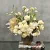 This arrangement is made with a designer&#039;s choice array of seasonal white