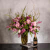 The grand display features an organic arrangement of fragrant lilacs, peonies, and