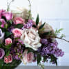 A beautiful floral arrangement featuring local lilacs and soft-colored roses set in