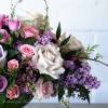A beautiful floral arrangement featuring local lilacs and soft-colored roses set in