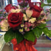 A rich collection of red Roses, Peruvian Lillies, and purple Monte Casino.