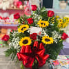 7 red roses and 4 sunflowers in basket with green filler and