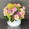 This beautiful floral design is arranged in a white ceramic vase. This
