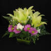 A clean design shows off these gorgeous lilies and delicate little spray