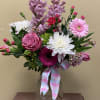 Clear glass vase with a beautiful variety of spring florals. 