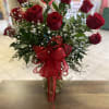 Twelve beautiful red roses arranged in a vase with baby&rsquo;s breath. Topped