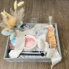 Box filled with candle, candle accessories, rose, stemless flutes, bud vase with