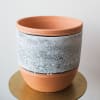 This pot is made of terracotta. There are two sizes available. 
Standard:
