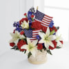 Red Carnations, white lilies and blue blooms beautifully say Happy Birthday America!