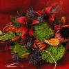 Winter seasonal arm bouquet with deep red tiger lilies, protea, green moss