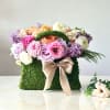 A gorgeous arrangement of seasonal flowers including roses, ranunculus, and tulips. Bound