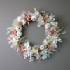 A modern dried wreath in off white, blush pink and earth tones.