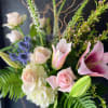 A fragrant arrangement with pink roses, lilles, and blues in a cluster-style
