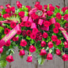 Luxurious. A statement. A full open couch casket spray of red roses
