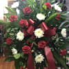  Standing spray with red and white flowers with assorted greenery on