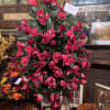 All red silk flowers on a stand for. Cemetery.