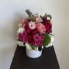this floral arrangement is designed in a white ceramic vase. This design