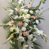 An elegant peach and white standing spray with a mix of seasonal