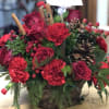 Red carnations, roses, pine cones and sprigs of cinnamon in a lovely