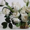 - Garden-inspired floral arrangement bursting with pristine white roses and lush green