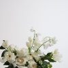 - Garden-inspired floral arrangement bursting with pristine white roses and lush green