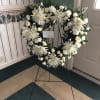 White spider mums, white mini carnations, and white spray roses with leather