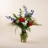 Red gerberas, blue delphinium, white stock, thistle, red carnations, trix dianthus, white