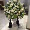 one-sided arrangement of white flowers in a lomey dish for the alter