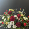 A keepsake crystal cross surrounded by florals in reds and whites with