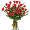 An impressive presentation of two dozen fragrant, long-stemmed red roses accented with