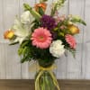 A traditional arrangment of pink, white, orange and purple flowers such as