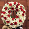 Standing wreath including white and red flowers.