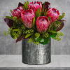 Pink mink proteas are arranged with seeded eucalyptus, plus galax and ti