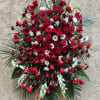Beautiful red spray arrangement featuring roses, daises, carnations, gladiolus, and green accents