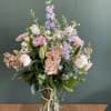 A soft tone, seasonal design of mixed summer blooms, arranged in a