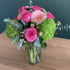 A collection of mixed pink tones in a clear glass cylinder vase.