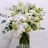 a beautiful mix of white flowers, including hydrangeas, orchids, and roses, complemented