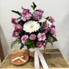 Is serene, elegant arrangement featuring vibrant, purple carnations paired with Chris White