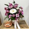 Is serene, elegant arrangement featuring vibrant, purple carnations paired with Chris White