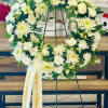 A 18&rdquo; wreath arranged with white florals and greenery. Ribbon with names