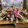 This is a casket spray that is created with bright pink flowers