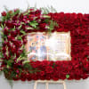 This frame includes a mix of roses and seasonal greens. Frames are