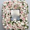 With a mix of white and pink roses, orchids and seasonal greens