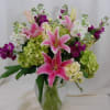 Green hydrangea, Pink oriental lilies, and colorful stock arranged in a clear