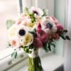 Hand tied bouquet-white anemones, pink ranunculus, cabbage roses, green Hypericum berries and