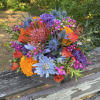 Tightly arranged flowers in a wooden box. Color palette varies throughout the