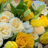 yellow roses with white spray roses, stocks, and asters in a one-sided