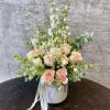 En elegant mix of rose, white delphinium, pink lisianthus, and greenery. Arranged