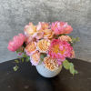 A moderately sized arrangement with peonies, eucalyptus, and various roses. 